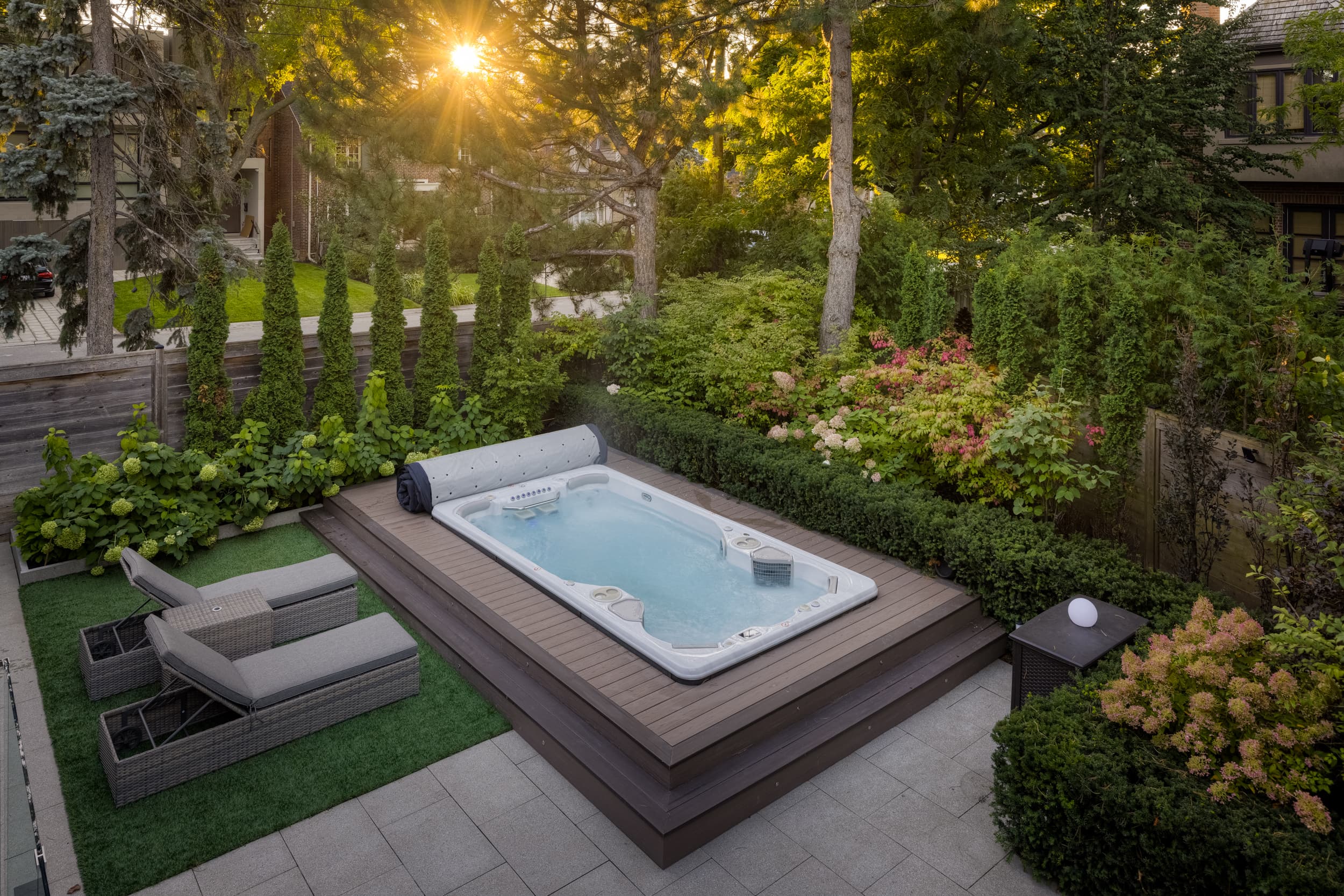 Hydropool swim spa installed in a lush Toronto backyard garden at sunset